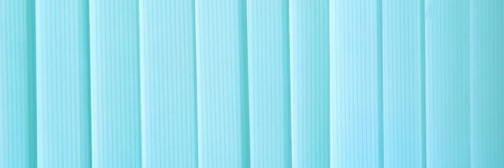 Obraz premium Blue ribbons closed the vertical window blinds. Abstract widescreeen panoramic view background. 
