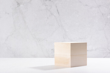 Beige natural cube podium in white and grey marble interior with sun light and shadow. Showcase for cosmetic products, goods, shoes, bags, watches.