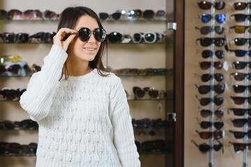 She made her choice. Beautiful young woman adjusting her new sunglasses and smiling while standing in optic store