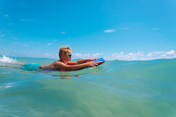 happy kid on the surfboard at sea, family vacation