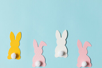 Easter paper bunnies on a blue background, space for text
