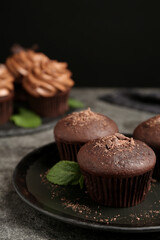 Delicious chocolate muffins served on grey table, closeup
