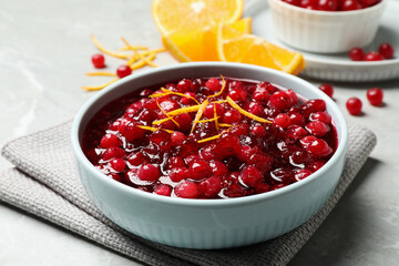 Fresh cranberry sauce with orange peel on light table