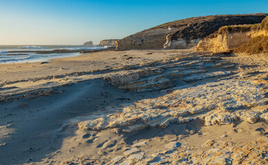 Beautiful landscapes of the Pacific coast, beach with human footprints, rocks, waves, sky, sun. Santa Cruz and Davenport have some of the most beautiful beaches in California.