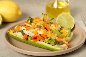 Baked stuffed zucchinis served with lime on light table, closeup