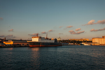 Cargo ship in sea and buildings on coast of Istanbul during sunset, Turkey