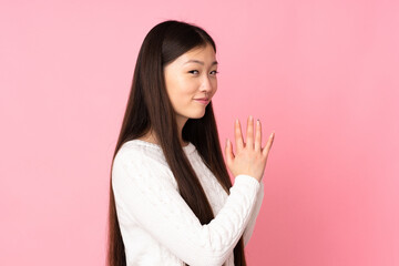 Young asian woman over isolated background scheming something