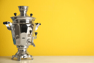 Traditional Russian samovar on yellow background. Space for text