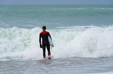 Surfeur se pr&eacute;parant &agrave; entrer dans la mer