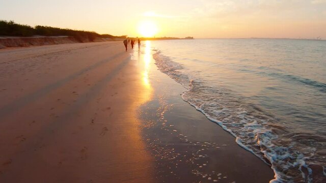 View of the sunset at the beach at Bet Dwarka in Gujarat, India. Summer holiday beach background. Silhouette of people walking on the beach. Travel and Holiday Concept, Summer Relaxation 