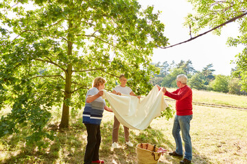 Fototapeta premium Three seniors spread a blanket together