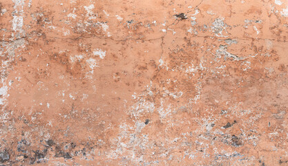 Stark verwitterte, apricotfarbene Wand - alte Fassade, teils mit sichtbaren schwarzen Lavasteinen