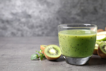 Delicious kiwi smoothie and fresh fruits on grey table. Space for text