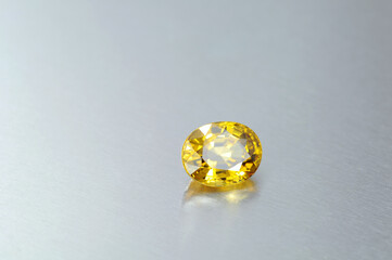 Natural clean free from inclusions bright yellow loose oval faceted zircon gemstone on light blue...
