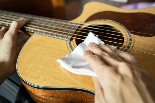 Cleaning acoustic guitar with microfiber cloth