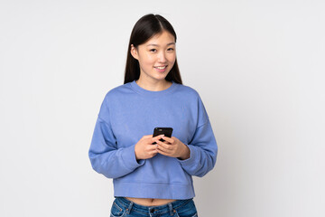 Young asian woman isolated on background sending a message with the mobile