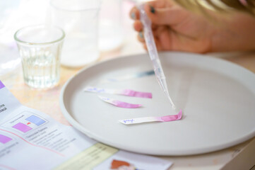 A girl plays with a children's chemical kit. Word Vinegar on the litmus paper.