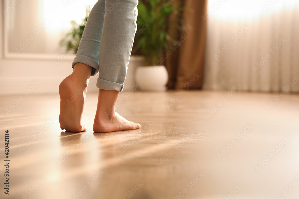 Poster Barefoot woman at home, closeup. Floor heating system