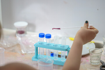A girl plays with a children's chemical kit