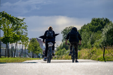 Obraz premium A guy and a girl ride bicycles, a view from the back.