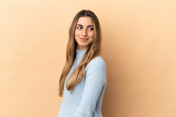 Obraz premium Young caucasian woman isolated on beige background . Portrait
