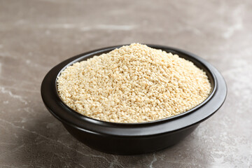 Sesame seeds in bowl on grey marble table