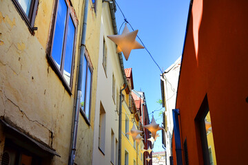 Fototapeta na wymiar Narrow pedestrian street with star shaped lanterns hanging above. Old Town of Riga, Latvia, Baltic States