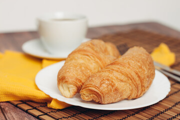 fresh croissants on a saucer table setting breakfast cup with drinks