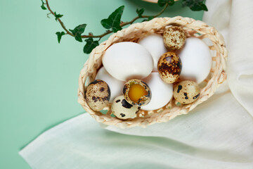 Flat lay easter composition with green leaves and easter eggs on a green background, Happy Easter, copy space, top view..