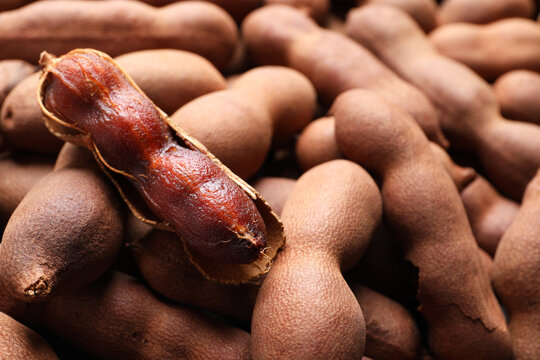 Delicious ripe tamarinds as background, closeup. Exotic fruit