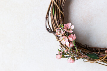 Detail of a decorative spring wreath made of twigs and flowers. DIY creativity. Close up.