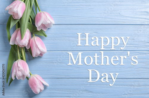 Happy Mother's Day. Beautiful tulips on light blue wooden background, flat lay