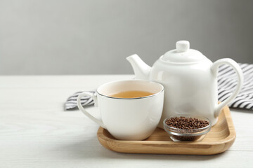 Obraz na płótnie Canvas Buckwheat tea and granules on white wooden table. Space for text
