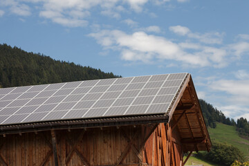 Fototapeta na wymiar Rural scene of an alpine barn with photovoltaic panels