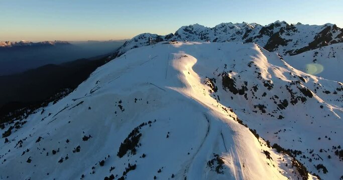 Downhill ski track at the Chamrousse French Alps during sunrise, Aerial dolly out shot