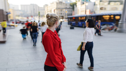 Outdoors portrait of beautiful young woman in a red blouse. Selective focus.