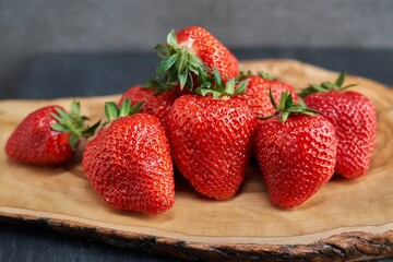 Close up image of fresh red strawberries on wooden board.