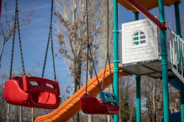 
Children's park with colorful toys. there is nobody in the park. there are no people or children. plastic children's swing close-up.