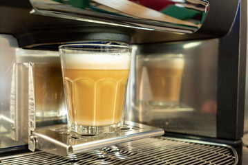 preparing a delicious cappuccino with ground roasted coffee beans and milk