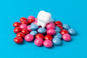 Sweets cause tooth decay. Teeth on a pile of candies.