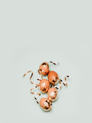 Fototapeta premium Holiday Easter golden and bronze eggs on blue background. Spring greeting card. Flat lay, top view.