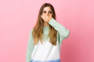 Fototapeta premium Young woman over isolated pink background covering mouth with hand