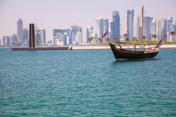 Fototapeta na wymiar Traditional dhow boats with the futuristic skyline of Doha in the background, Qatar,12/23/2016 