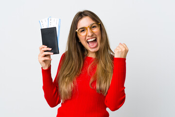 Young woman over isolated white background happy in vacation with passport and plane tickets