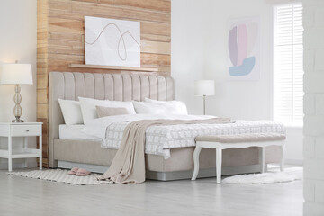 Stylish room interior with large comfortable bed
