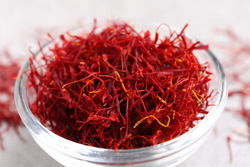 Fototapeta premium Dried saffron in glass bowl on table, closeup