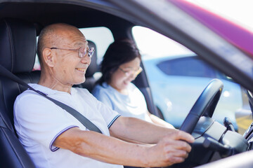 車を運転するおじいさんとおばあさん