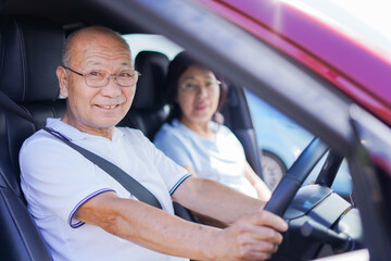 車を運転するおじいさんとおばあさん