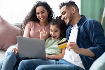 Arabic Family Of Three With Laptop And Credit Card Making Online Shopping