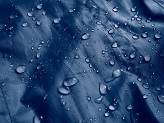 Water drops on waterproof membrane fabric. Detail view of texture of blue waterproof cloth.